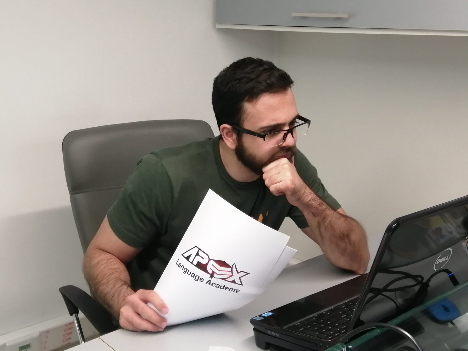 An Apex student reading on his laptop